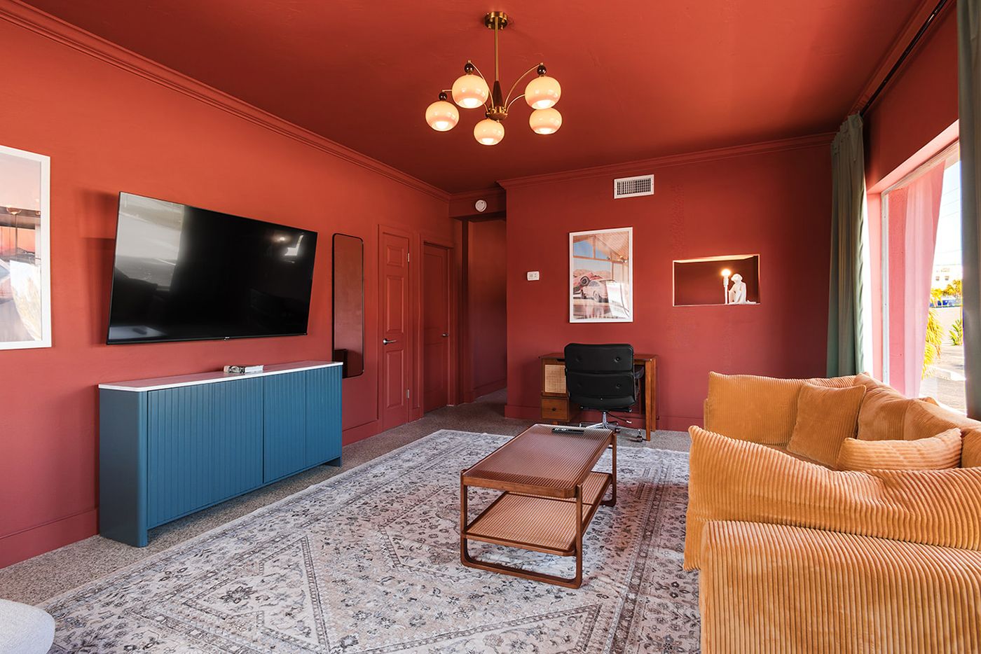 After: terracotta living room with a teal credenza, corduroy sofa and globe chandelier